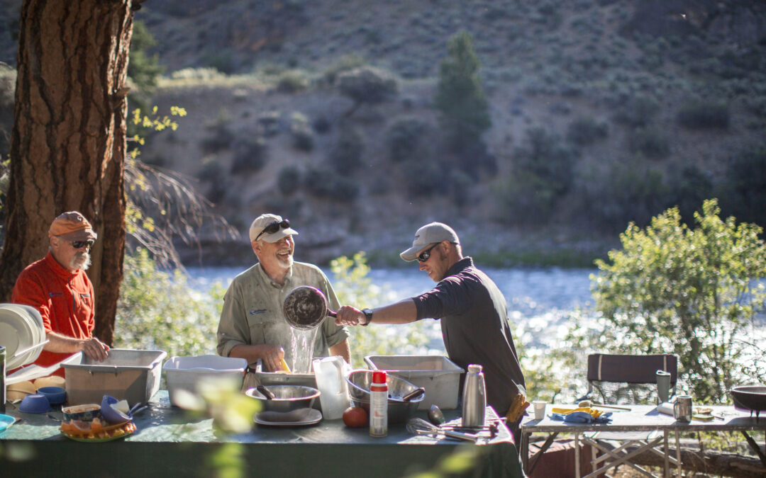 friends cooking together on the river