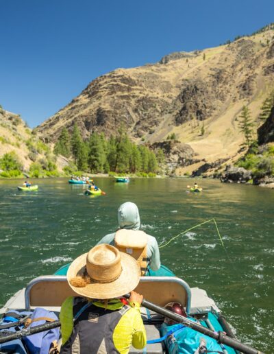 a group of rafts floating down clear teal water in the summer time