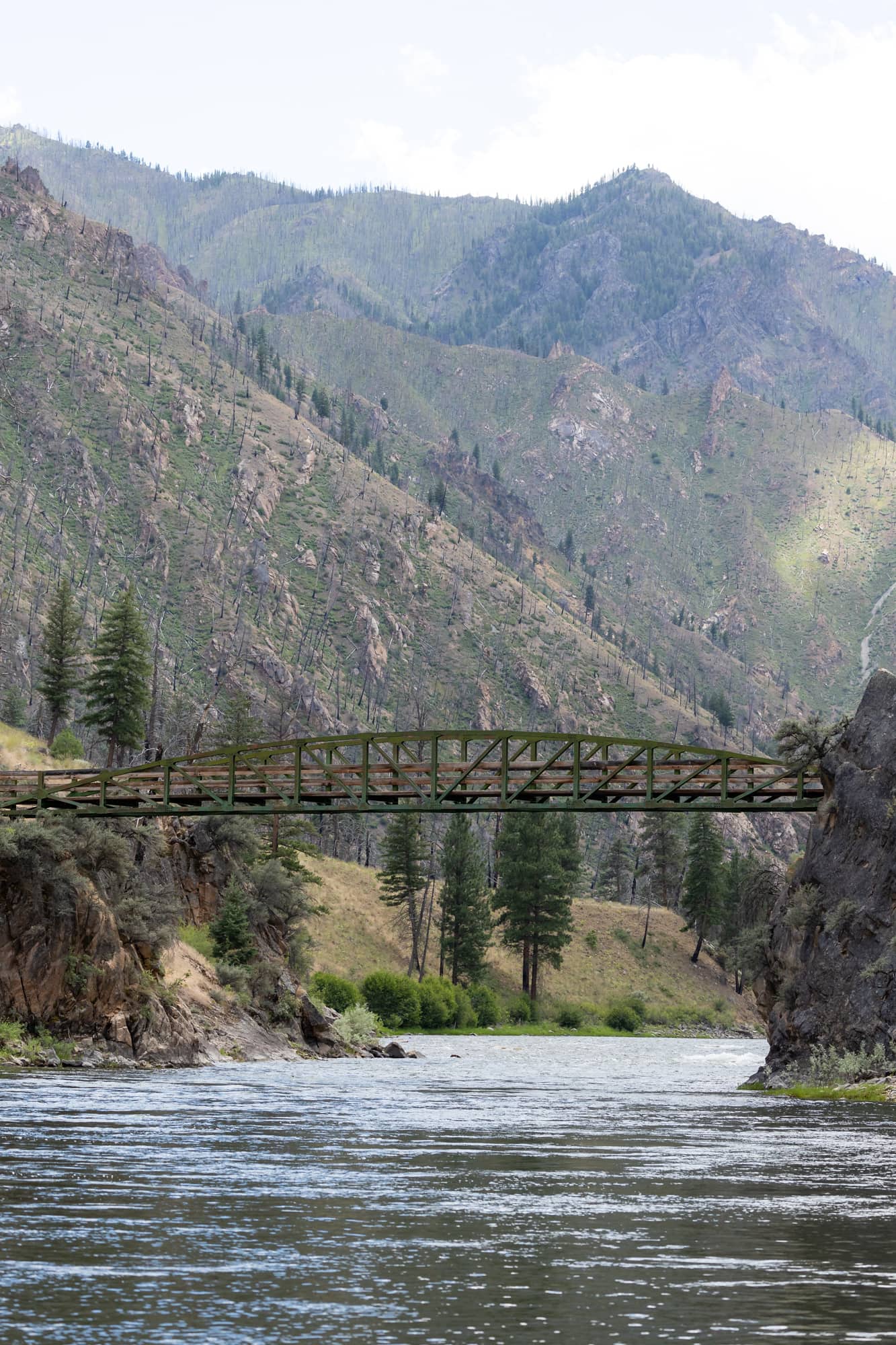 Hiking the Middle Fork River trail takes you over the White Creek Bridge, high above the water and with a dramatic mountainous backdrop.